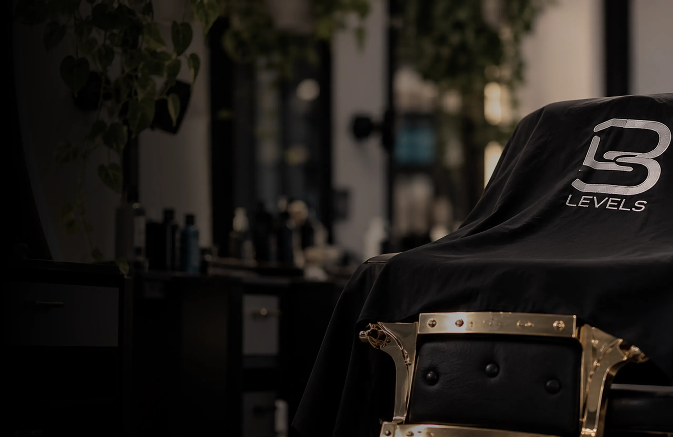 Silla de barbero dorada cubierta con una capa negra en el local de Jireh